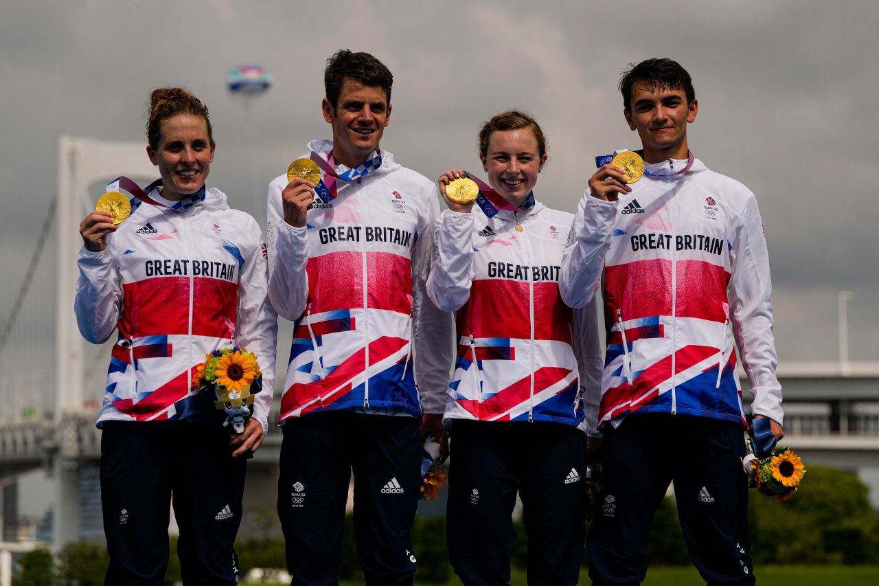 Members of team Britain celebrate on the medal stand after winning gold medal in the mixed relay triathlon on July 31.