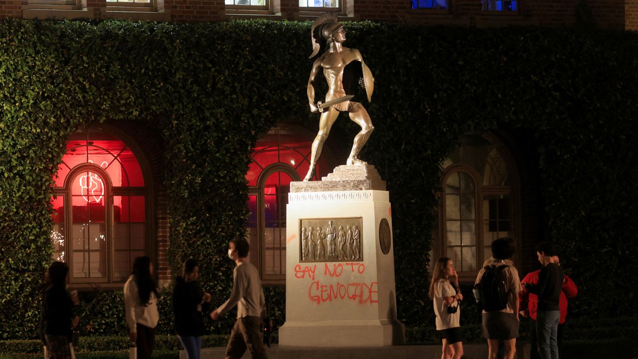 People stand near a vandalized statue at the University of Southern California in Los Angeles, on April 27. 