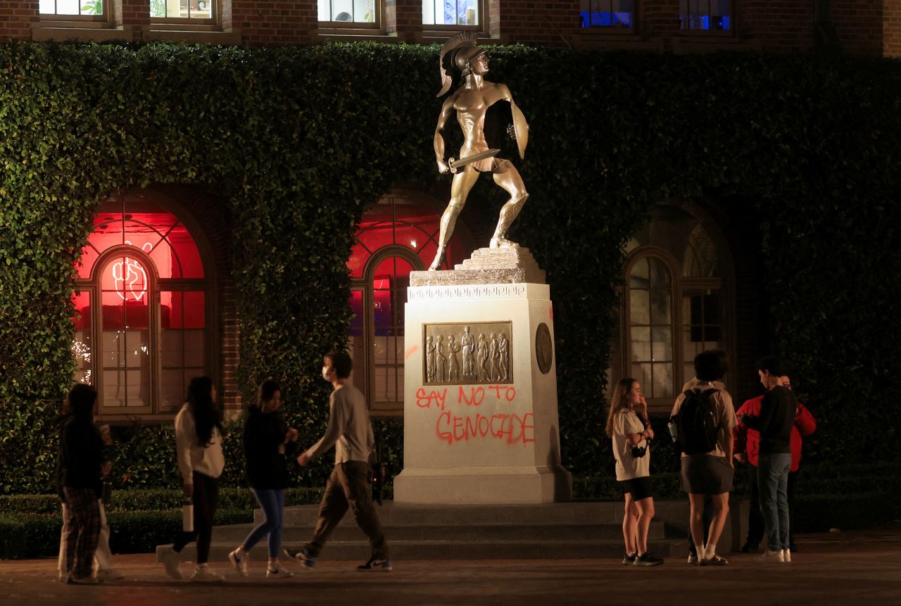 People stand near a vandalized statue at the University of Southern California in Los Angeles, on April 27. 