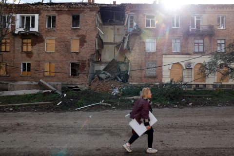 A woman walks past a building damaged by missile strikes in the eastern Donbas region of Bakhmut, Ukraine, on November 1.