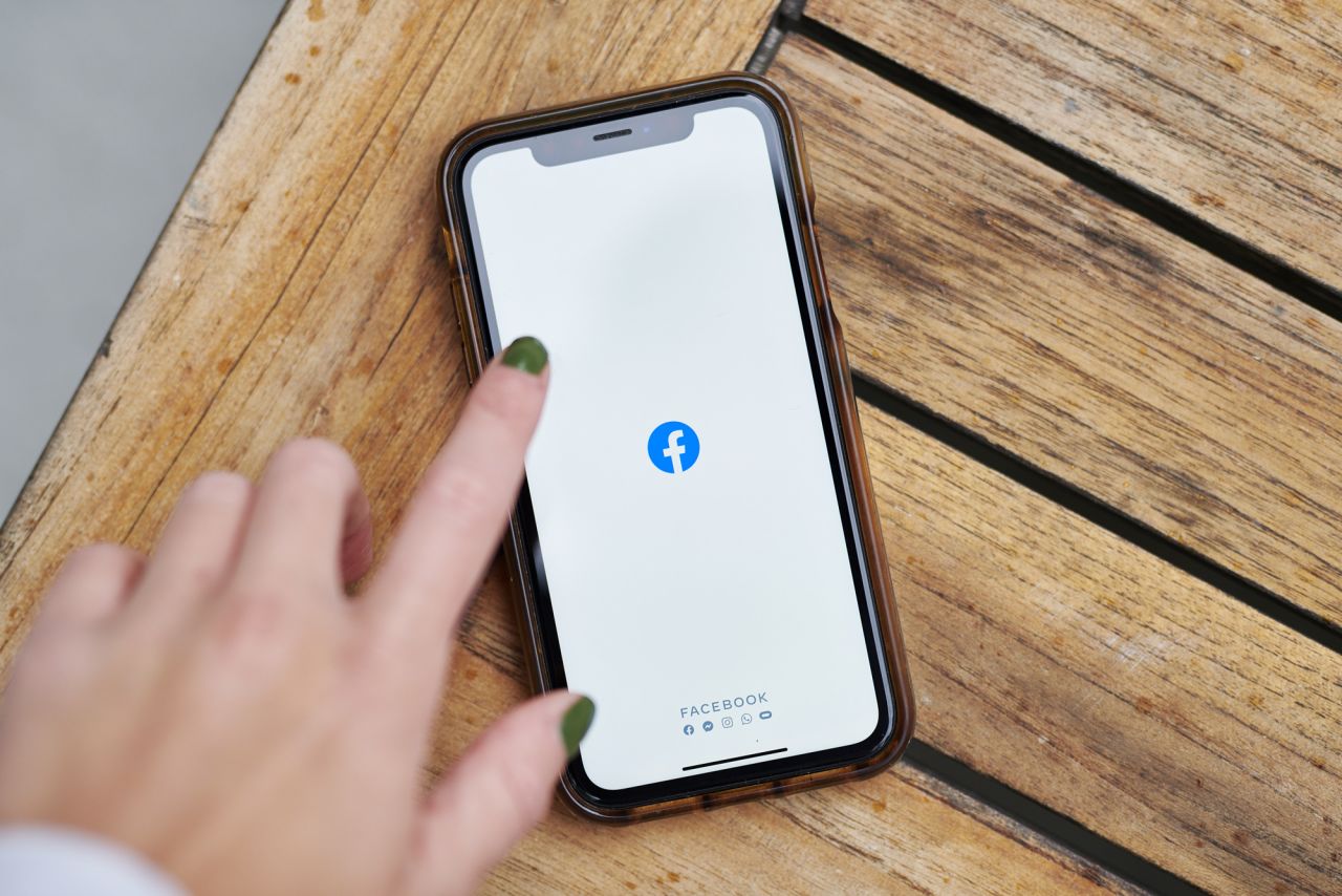 The logo for Facebook is displayed on a smartphone.