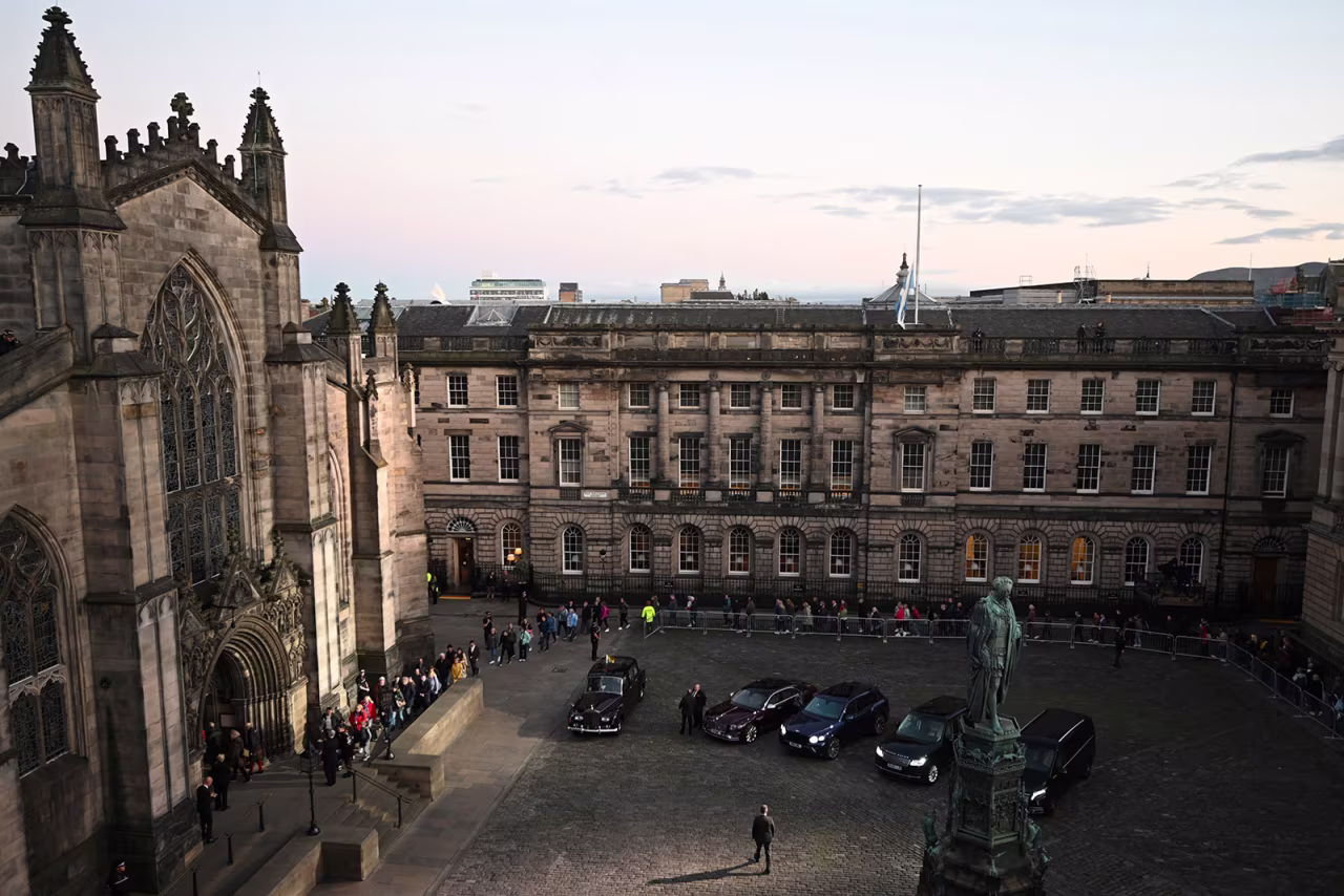 People wait outside of St. Giles' Cathedral to pay their respects to Queen Elizabeth II Monday evening.
