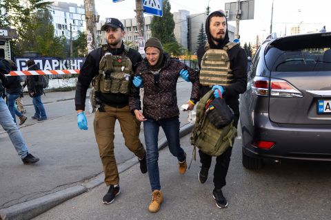 A woman is rescued as Ukraine's capital is rocked by explosions during a drone attack in the early morning on Monday in Kyiv, Ukraine.