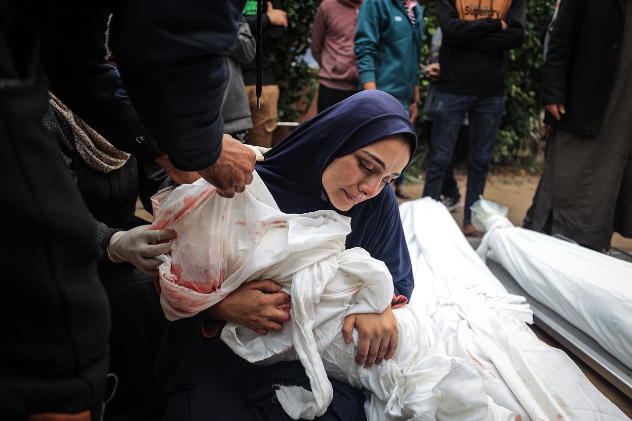 Relatives of Palestinians killed in Israeli attacks on an UNRWA school in Khan Younis bid farewell in front of the Nasser Medical Hospital morgue on December 5.