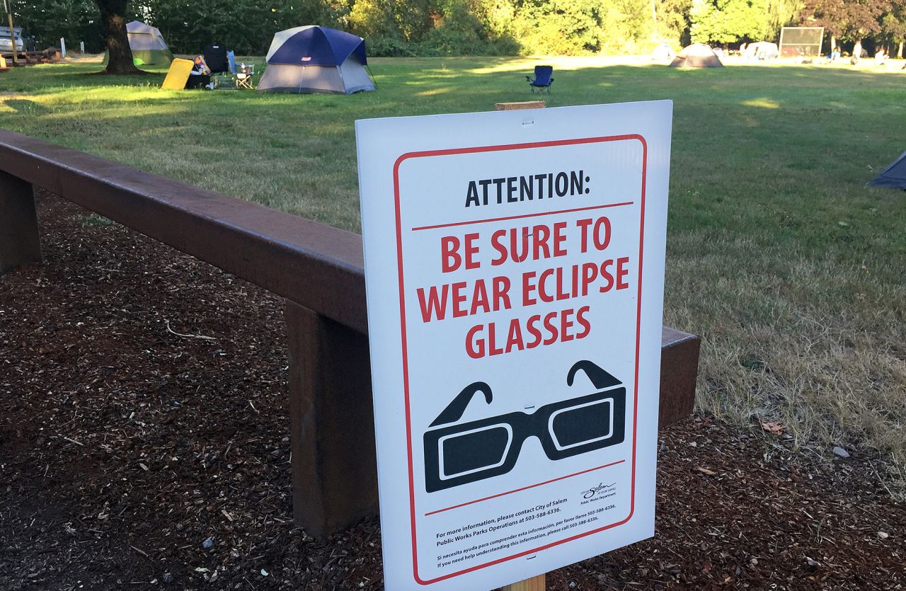 Signs advising people to wear eclipse glasses are posted in Cascades Gateway Park, in Salem, Oregon, on August 21, 2017. 