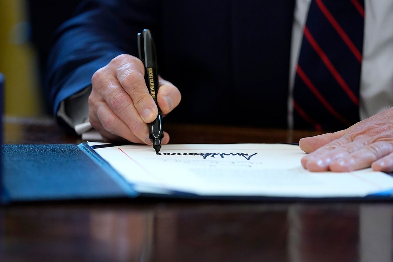 President Trump signs the coronavirus stimulus relief package in the Oval Office at the White House on Friday, March 27.