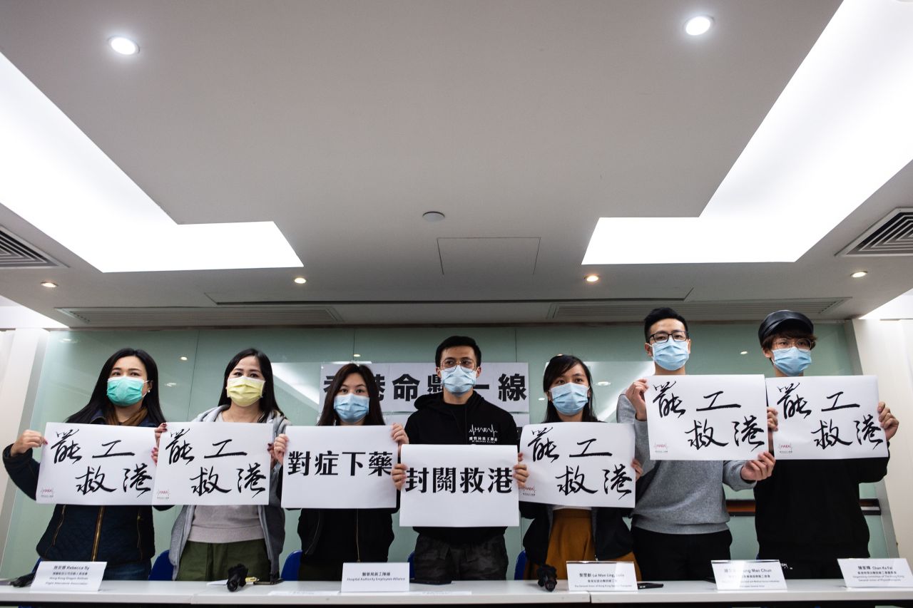 Members of various Hong Kong unions hold slogans as they pose for pictures for the media during a news conference on the latest update of the strike actions in Hong Kong on Sunday.