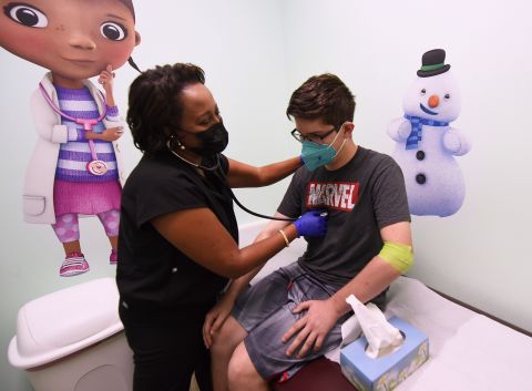 Dr. Salma Elfaki examines 16-year-old Diego Alvarez, a patient in a Moderna COVID-19 vaccine clinical trial for adolescents being conducted by Accel Research Sites with Nona Pediatric Center in Orlando, Florida.