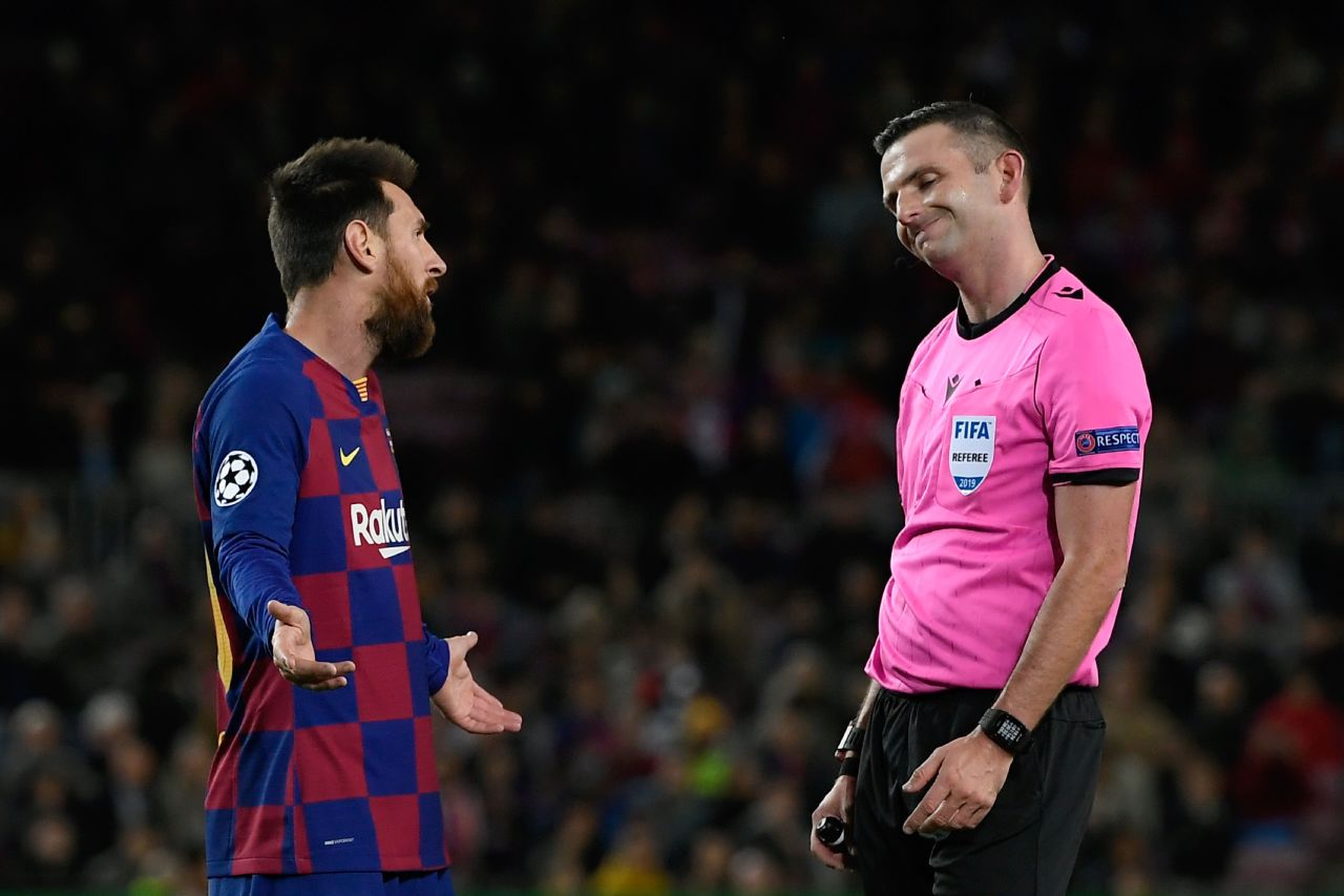 Lionel Messi argues with referee Michael Oliver.