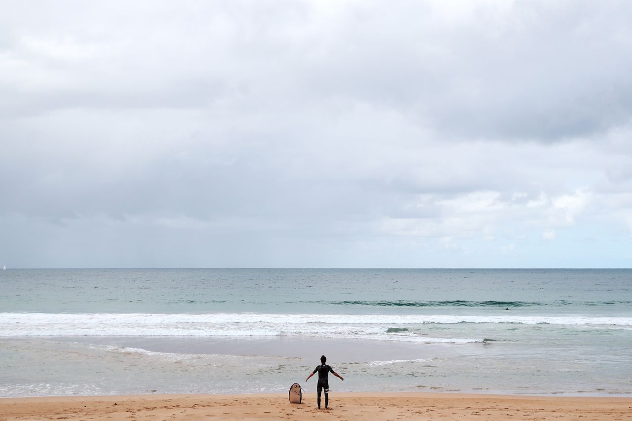 A surfer is seen on Manly Beach as the majority of residents and tourists follow the government's advice to self-isolate on March 23 in Sydney, Australia.