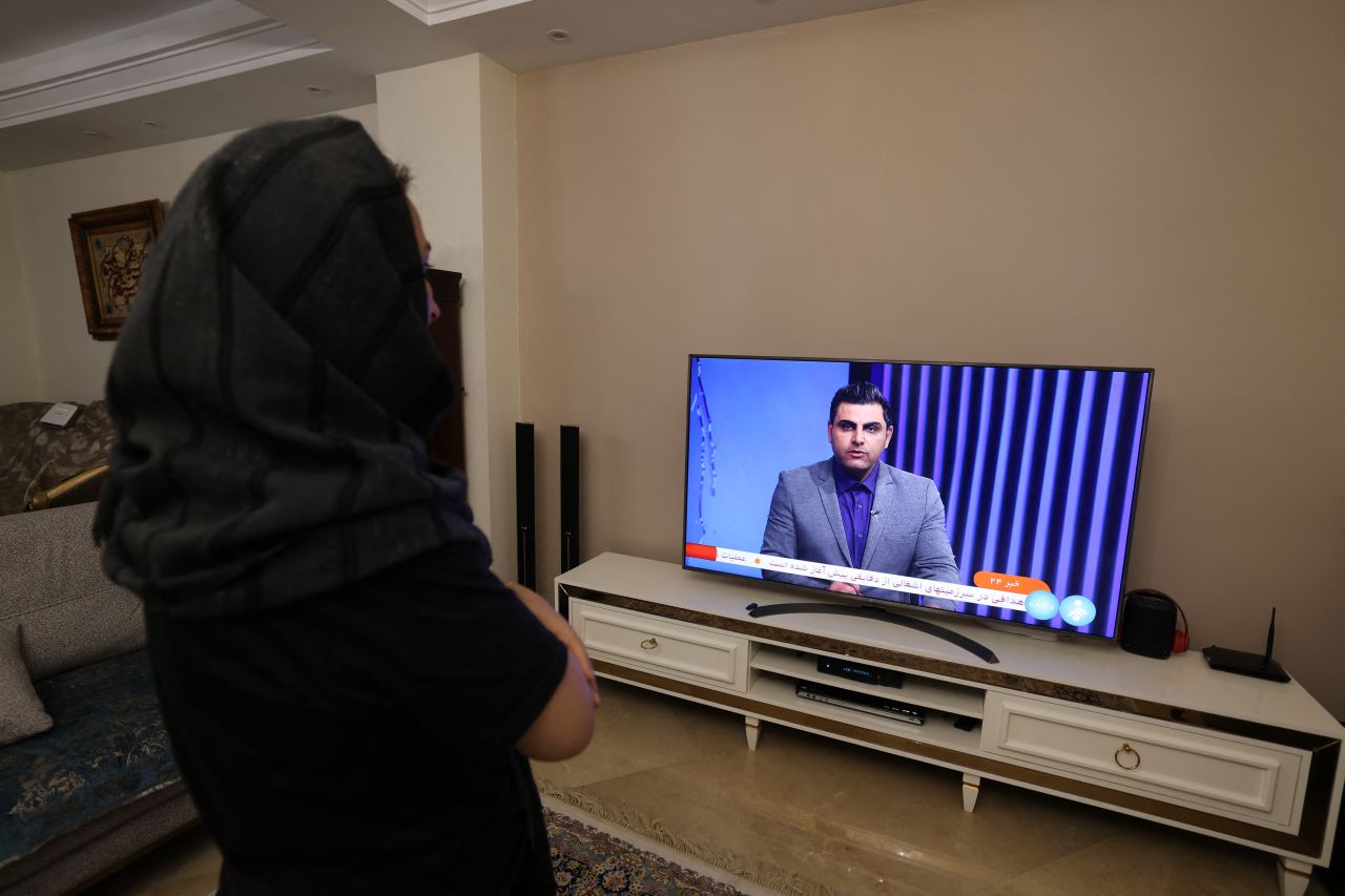 An Iranian woman watches an Iranian news TV channel, which is covering Iran's attack on Israel, in Tehran on April 14.