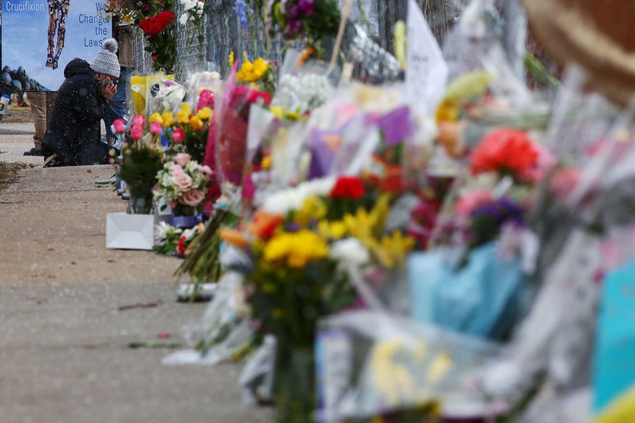 A person pays their respects at the memorial outside of King Soopers. 