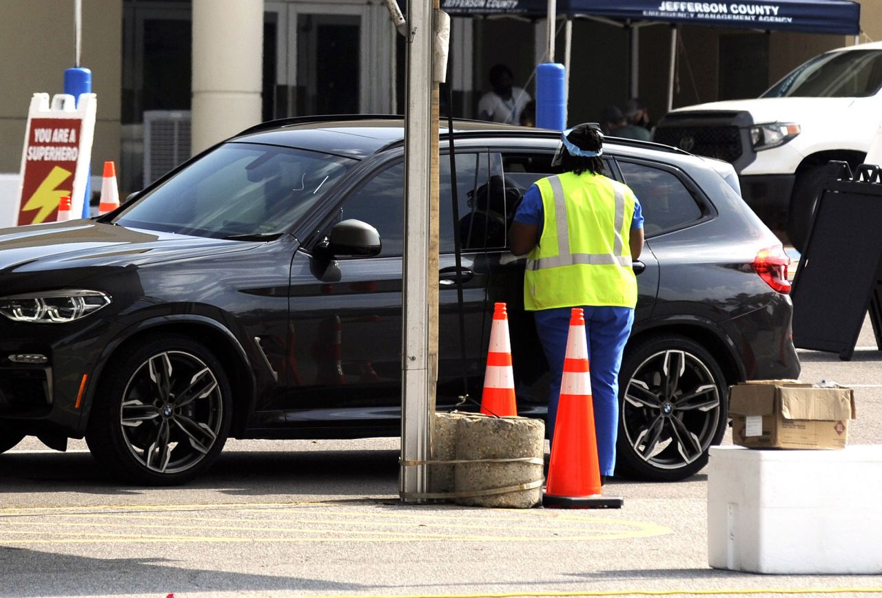 A worker at a coronavirus testing site speaks with someone through a car window in Hoover, Alabama, on Tuesday, September 1.