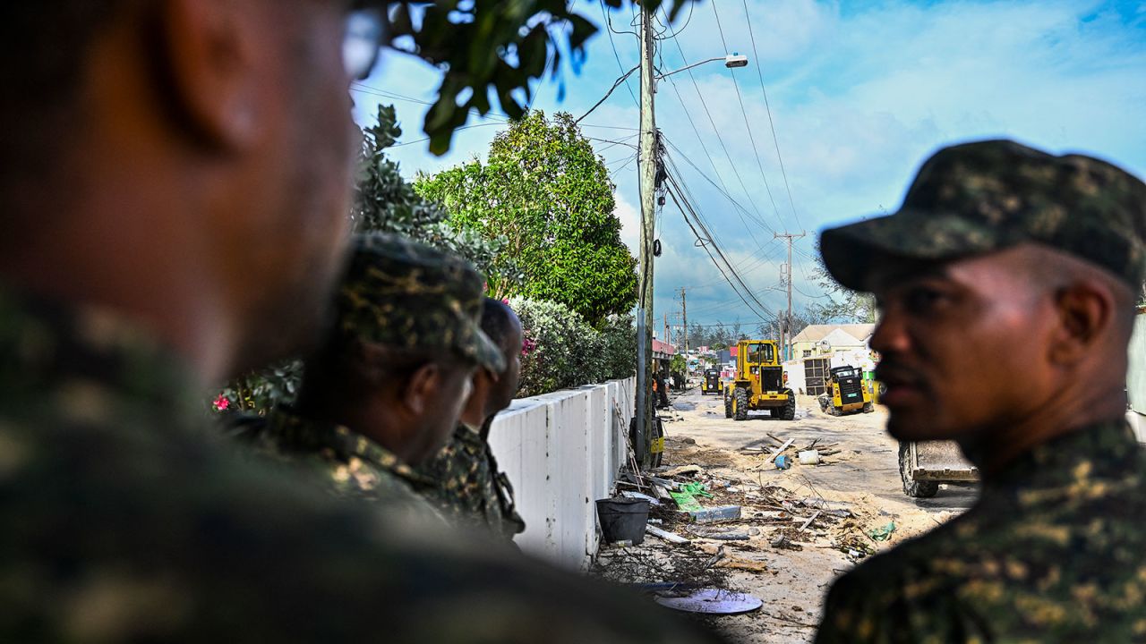 Members of Barbados National Armed Forces clear a street of sand as it gets flooded by sea water after the passage of Hurricane Beryl in Oistins, Barbados, on Monday.