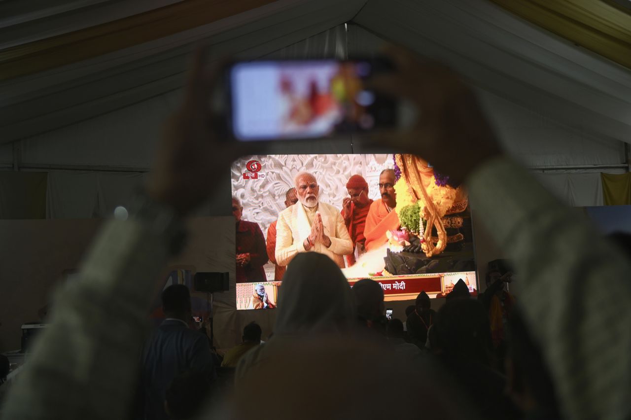 People watching the Ram temple consecration ceremony by Prime Minister of India, Narendra Modi, on a live streaming screen in a media center in Ayodhya, India, on January 22.