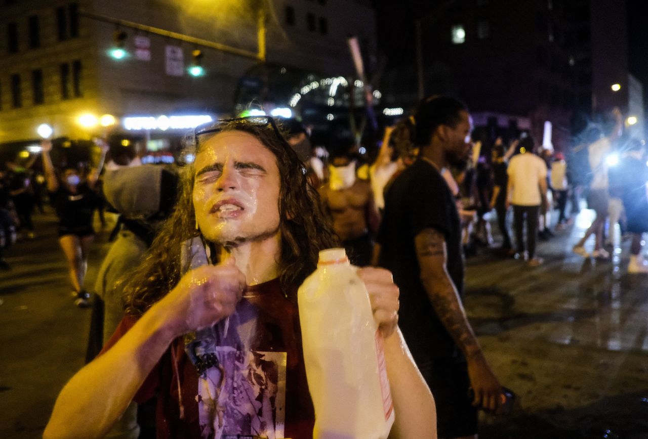 A protester pours what appears to be milk on their face during a demonstration in Columbus, Ohio, on May 28.