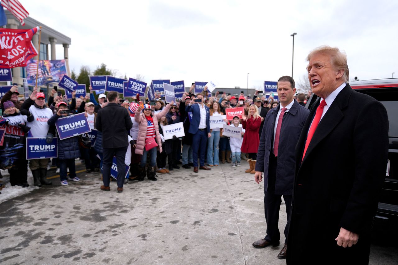 Former President Donald Trump greets supporters as he arrives in Londonderry, New Hampshire.