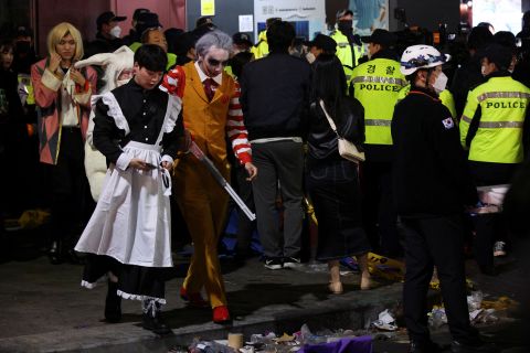 Partygoers leave the the scene following a stampede during a Halloween festival in Seoul on October 30.