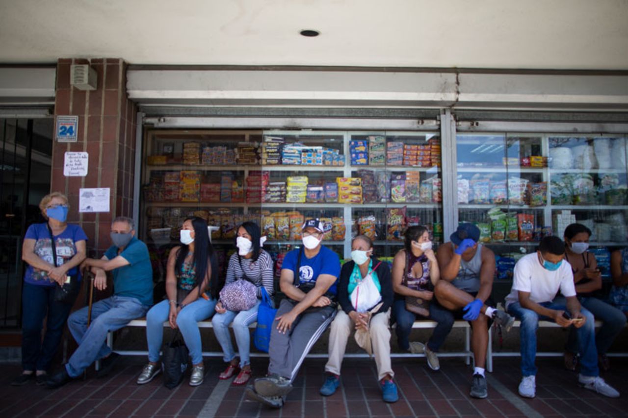 Customers wait to go into a supermarket in Caracas, Venezuela, Monday, March 16. 