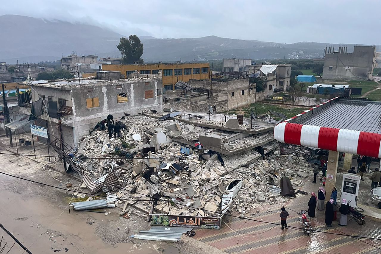 People search through the wreckage of a collapsed building in Azmarin, northwestern Syria, on Monday, February 6. 