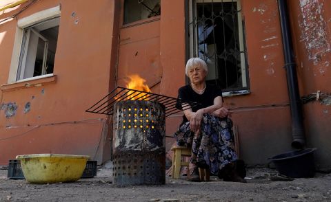 A woman cooks in the yard of a house in the city of Mariupol, Ukraine, on June 4.