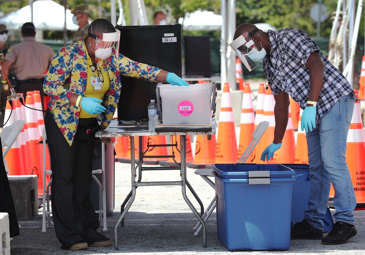 Health care workers wait for people to arrive to be tested at the Covid-19 walk up testing site that opened on April 27, in North Miami, Florida.