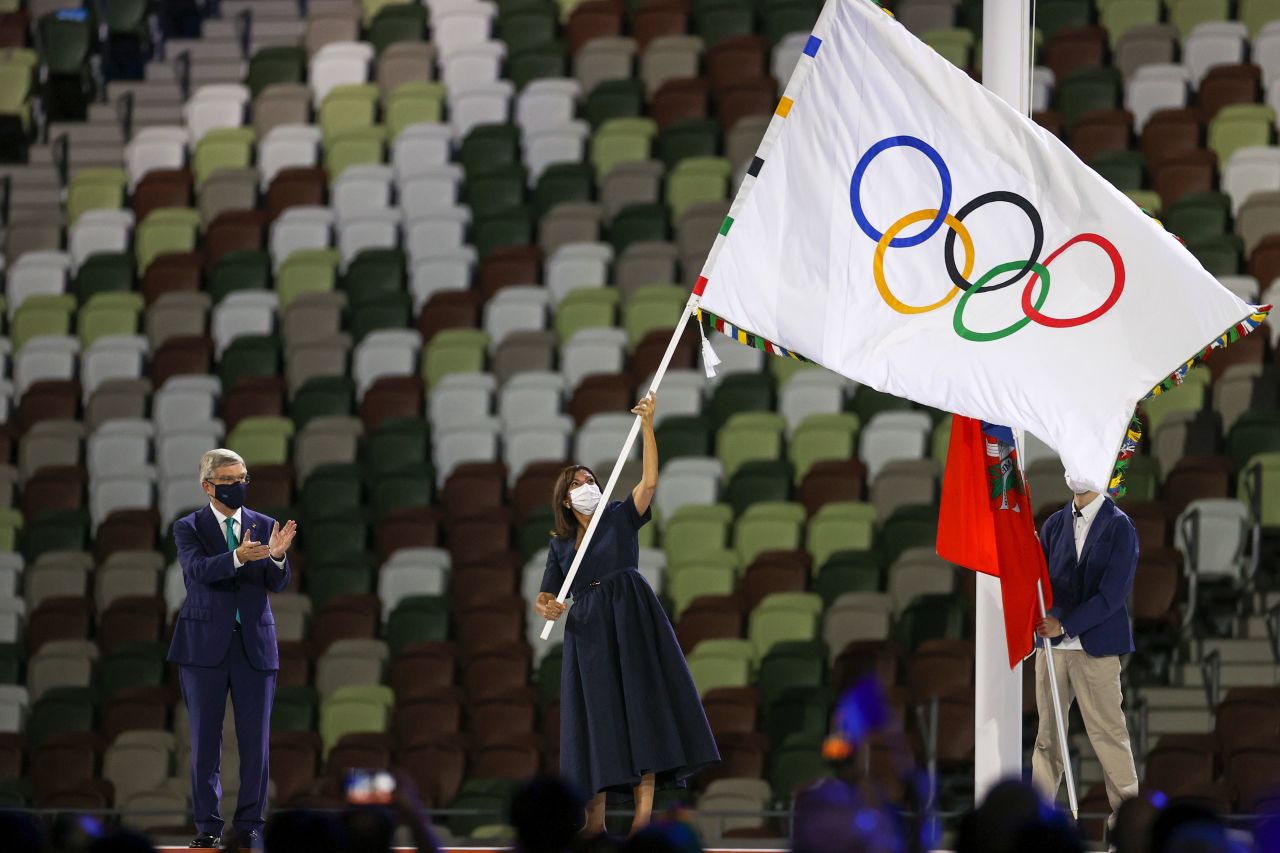 Paris Mayor Anne Hidalgo waves the Olympic flag.