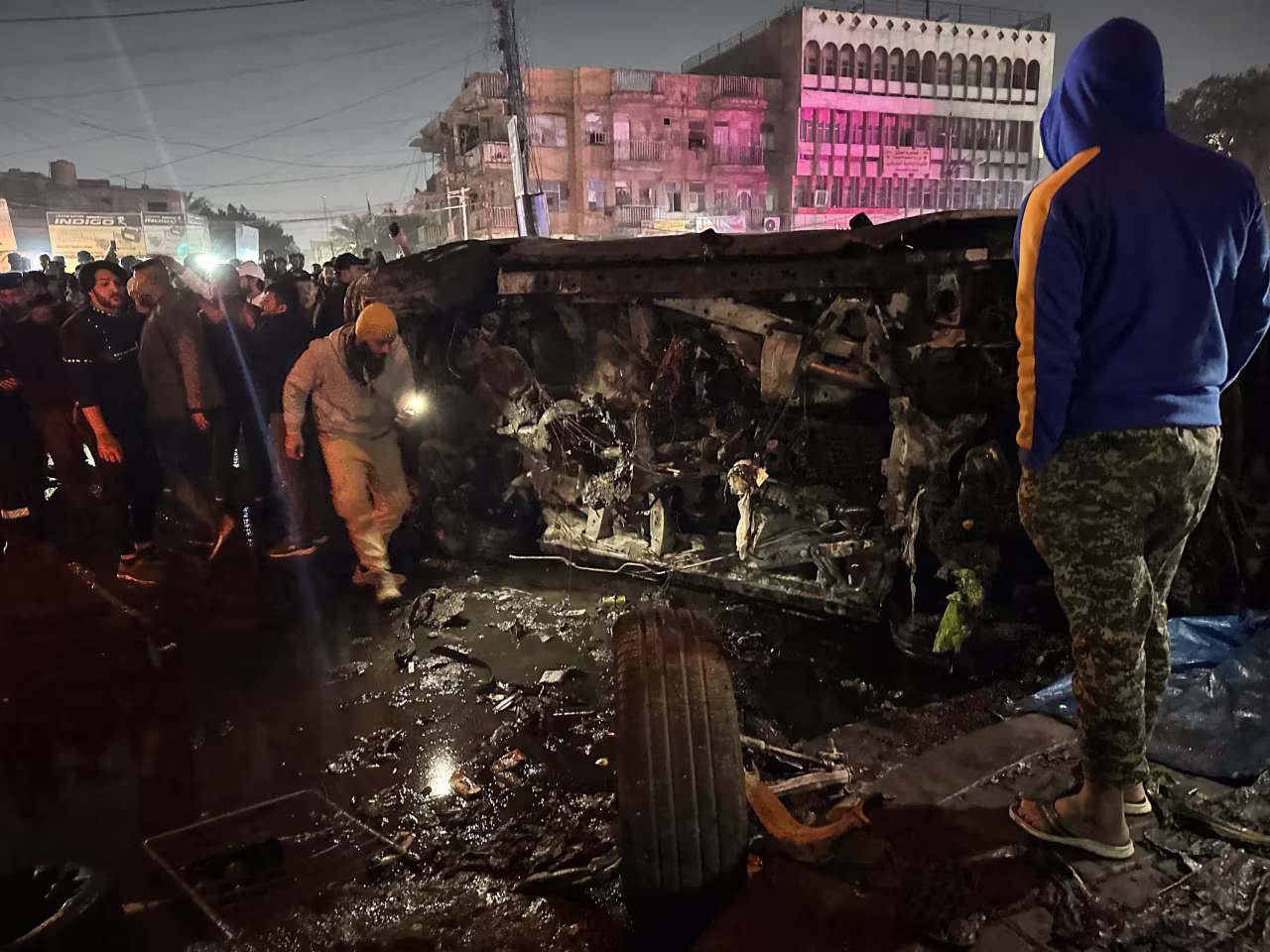 People inspect a vehicle after what security sources said was a deadly drone strike, in Baghdad, Iraq, on February 7. 