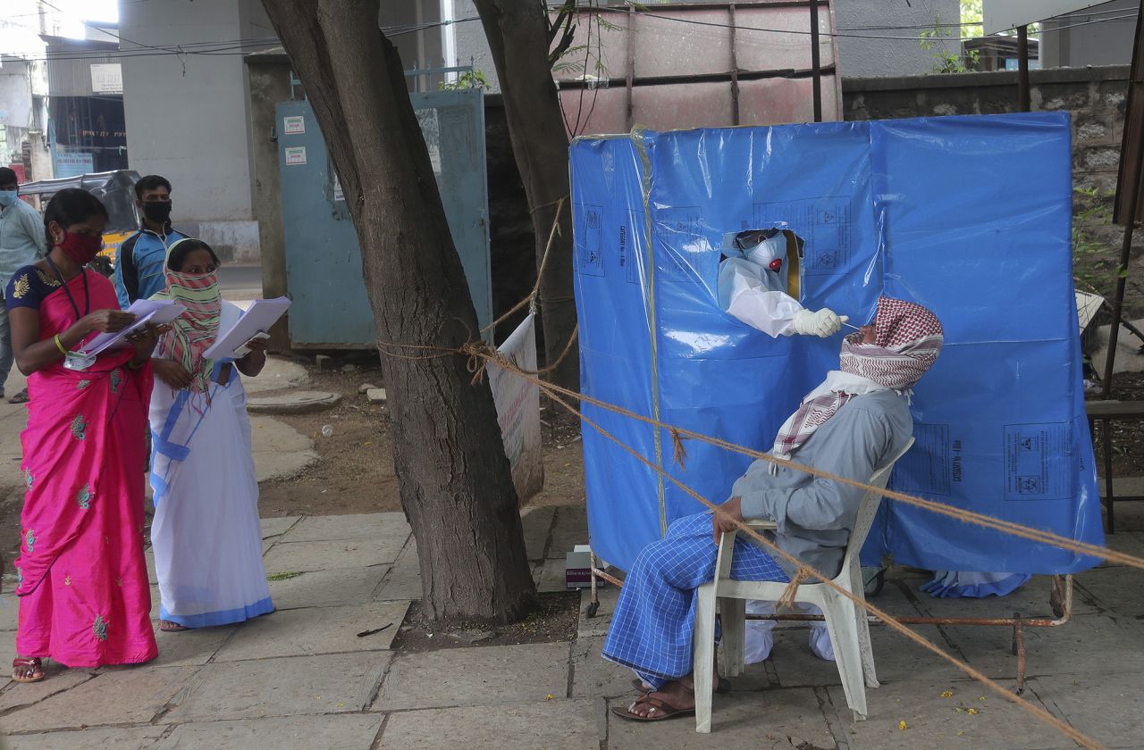 A health worker takes a nasal swab sample to test for COVID-19 in Hyderabad, India, on Saturday, August 22. 