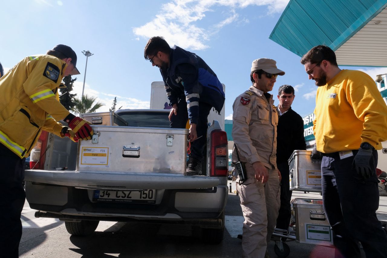 A rescue worker from Germany's fire and rescue service and a Turkish officer handle equipment outside Adana Airport, Turkey, on Tuesday,