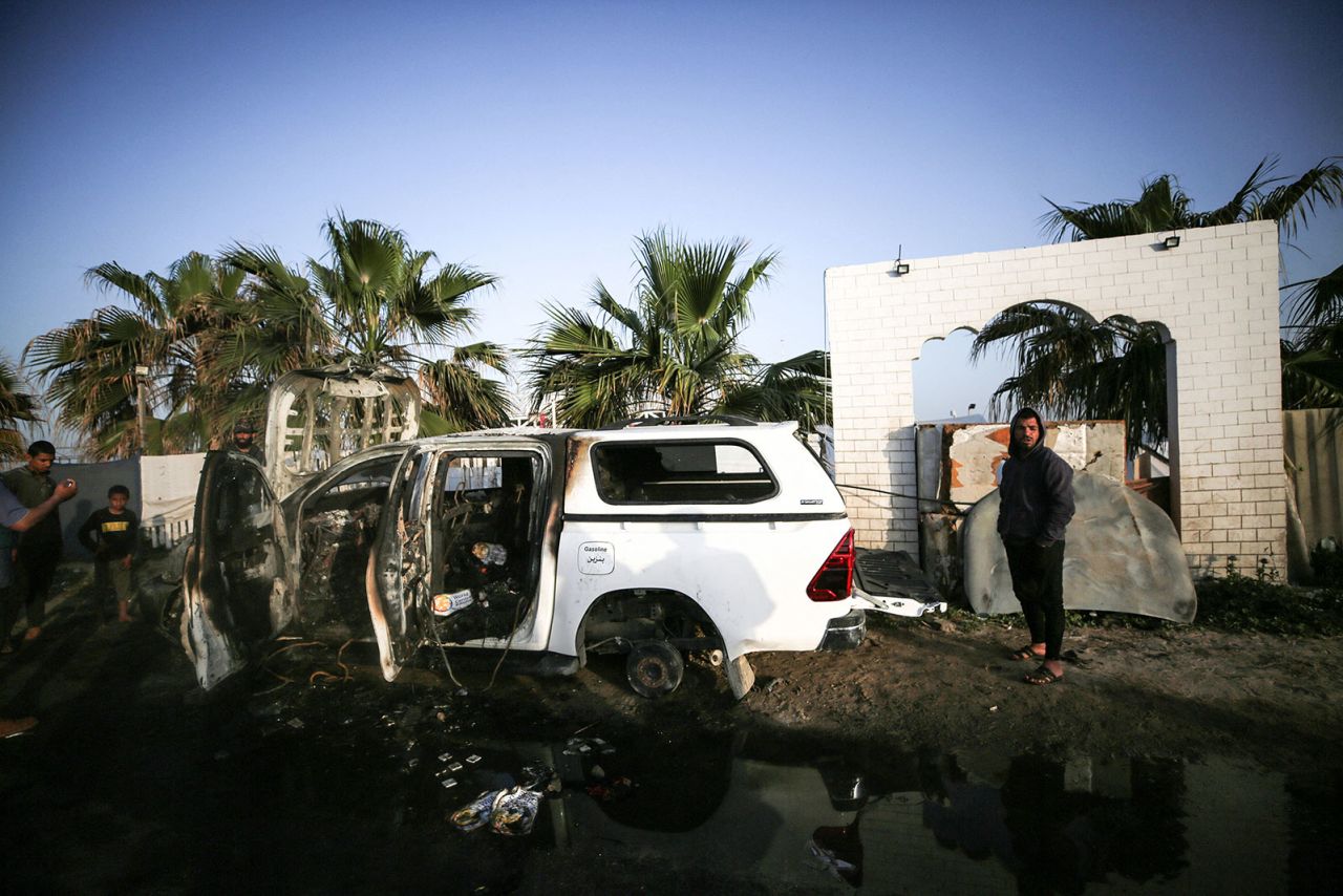 Palestinians stand next to a vehicle in Deir Al-Balah, in central Gaza, on Tuesday, April 2, where employees from the World Central Kitchenwere killed in an Israeli airstrike.