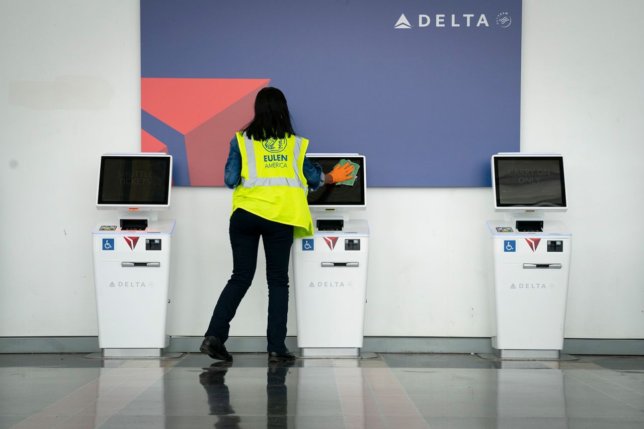 A worker cleans the screens at a Delta self check-in kiosk at Ronald Reagan Washington National Airport, on May 5, in Arlington, Virginia.