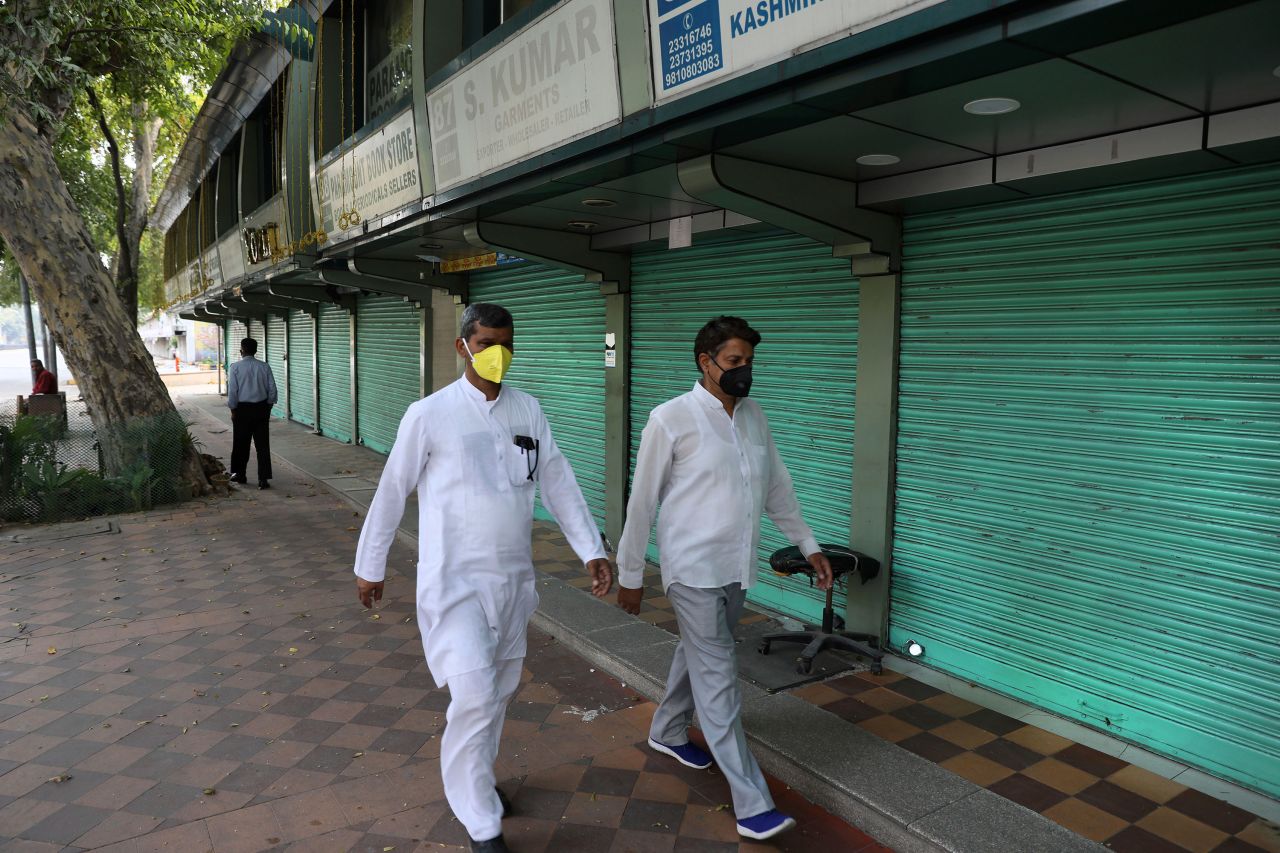 People walk past closed shops in New Delhi on March 23, the first day of the lockdown.