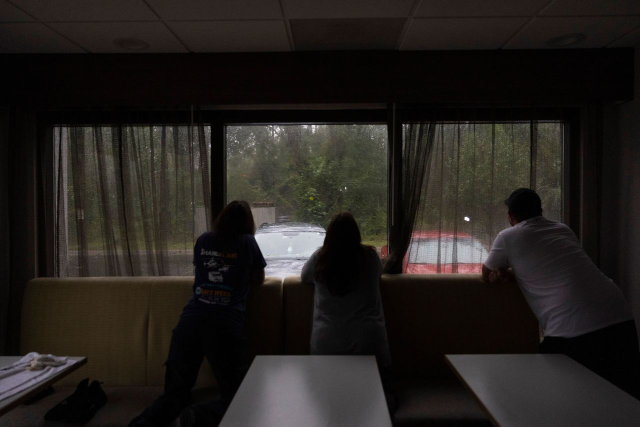 Visitors look out of a hotel window as Hurricane Debby makes landfall in Perry, Florida, on Monday, August 5. 