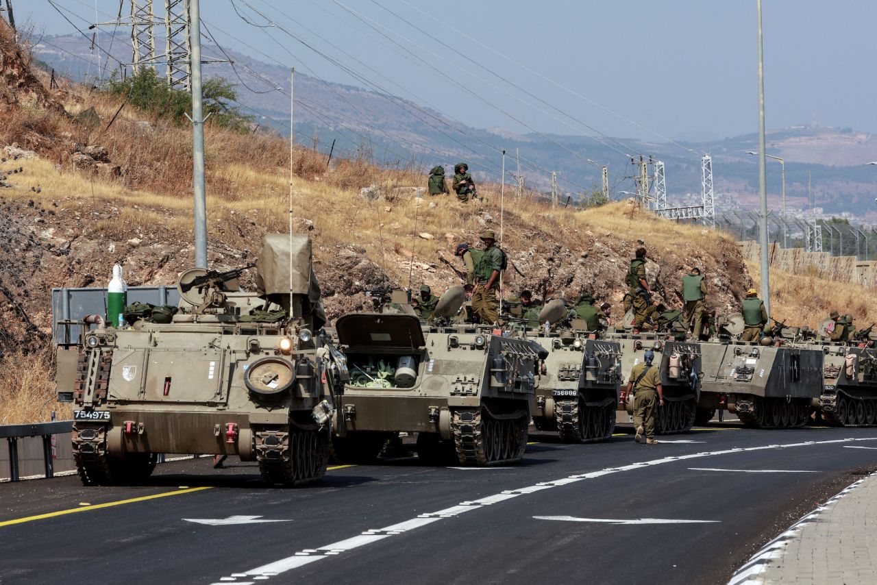 A convoy of?Israeli armored vehicles drive on a road near?Israel's border with?Lebanon on Monday.