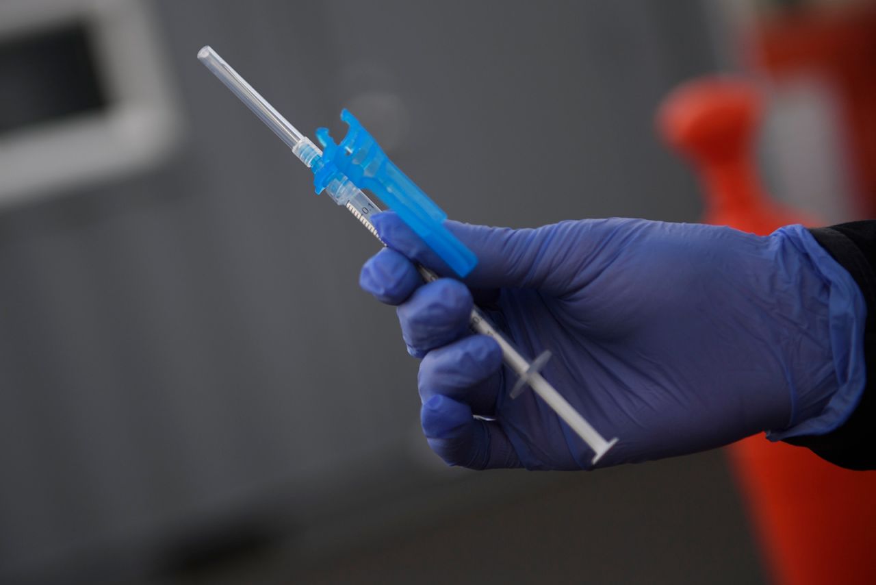 A registered nurse holds a syringe with the first dose of the Pfizer-BioNTech Covid-19 vaccine to be administered to a front-line health care worker under an emergency use authorization at a drive up vaccination site from Renown Health in Reno, Nevada on December 17.