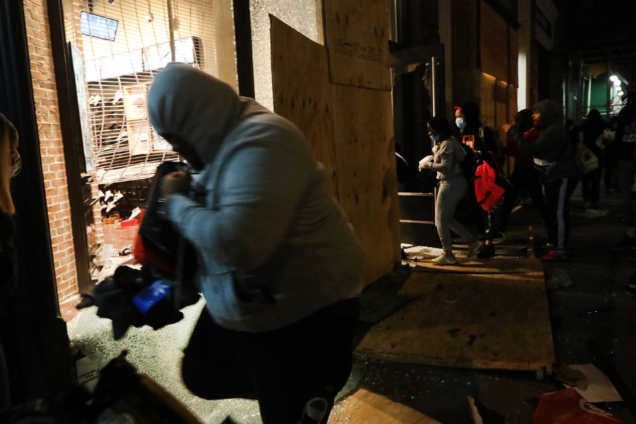 People run out of stores on Broadway with merchandise during a night of protests and vandalism over the death of George Floyd on June 1, in New York City. 