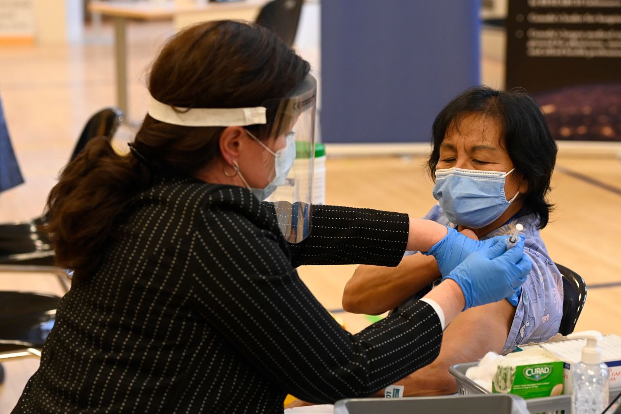 Tamara Dus, left, director of University Health Network Safety Services, administers Pfizer-BioNTech Covid-19 vaccine in Canada to personal support worker Anita Quidangen in Toronto on December 14.
