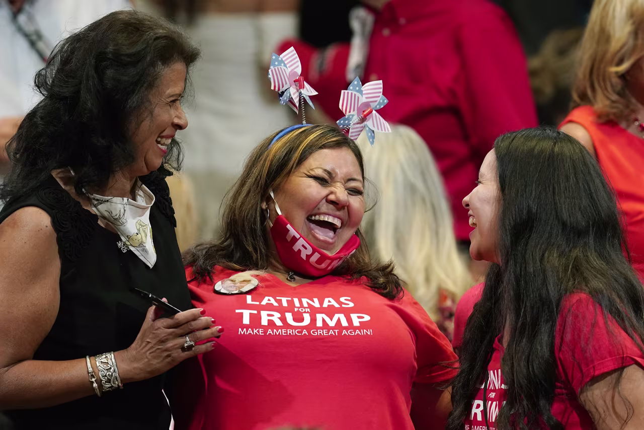Supporters of President Donald Trump share a laugh as they wait for the president to participate in a Latinos for Trump Coalition round table on Monday in Phoenix. 