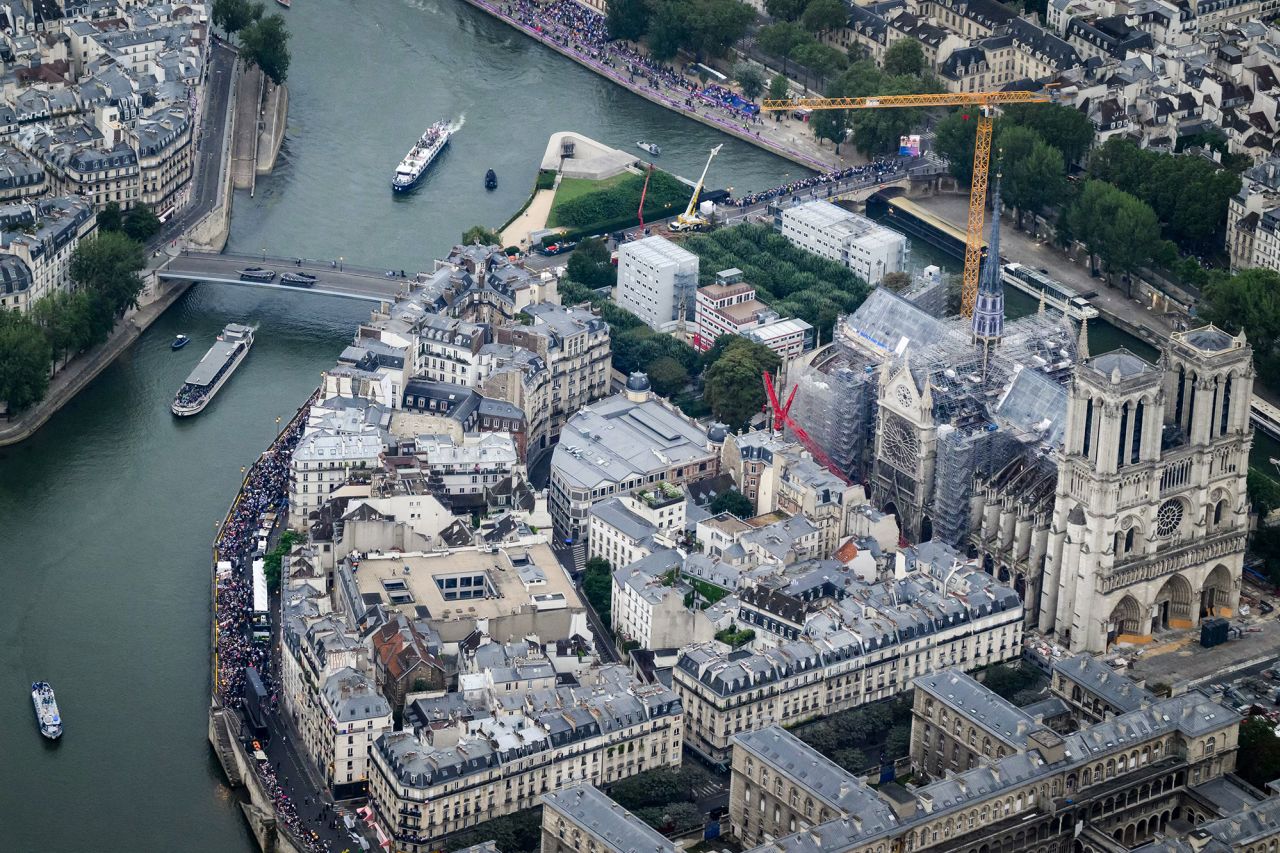 A view of Notre-Dame de Paris Cathedral as delegations boats navigates on the Seine past the Ile de la Cite Island during the opening ceremony.