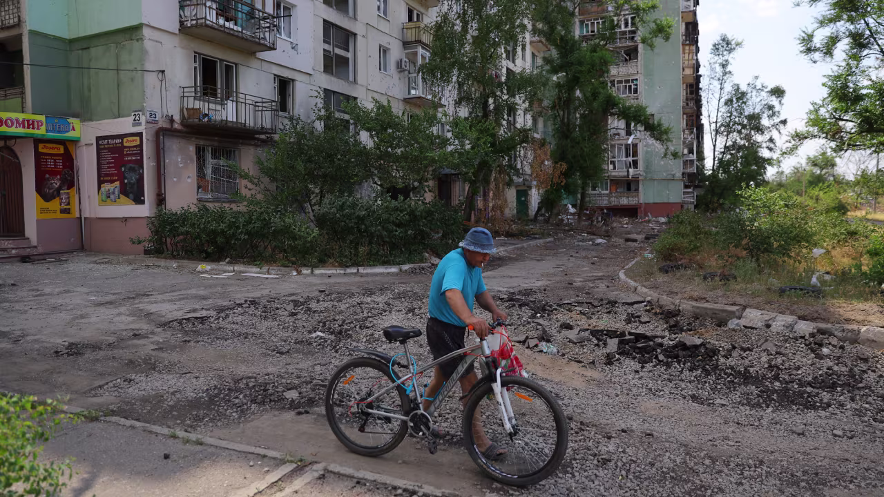 A resident walks a bike past a building in Severodonetsk, Ukraine, on July 1.