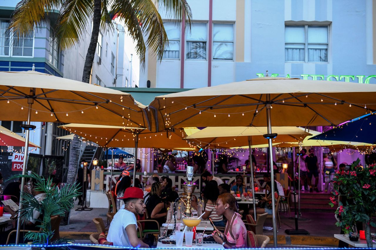 People eat outside of a restaurant on Ocean Drive in Miami Beach, Florida, on June 26.