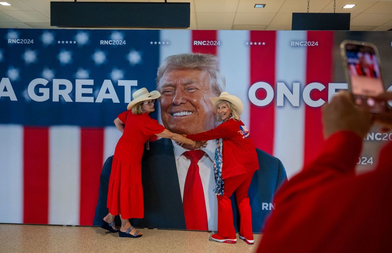 Kay Hall and Sharon Henson, both from Texas, pose with a Trump poster on Monday.