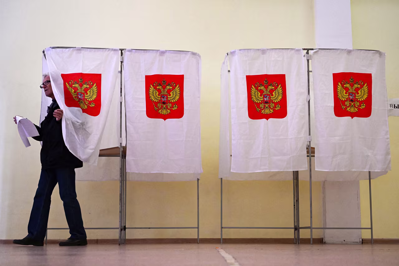 A man leaves a voting booth during the Moscow municipal deputies elections at a polling station in Moscow on September 9.