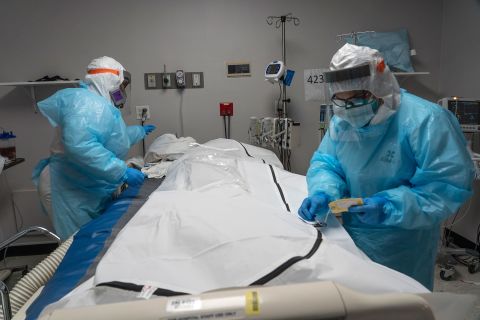 Medical staff members close the zipper of a body bag containing a deceased Covid-19 patient in the intensive care unit of United Memorial Medical Center on November 25 in Houston, Texas. 