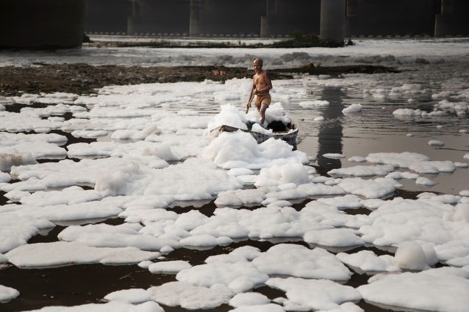 A Hindu man makes the Chhath Puja pilgrimage along Delhi’s Yamuna River. The sacred water is polluted, jeopardizing both human and aquatic health.