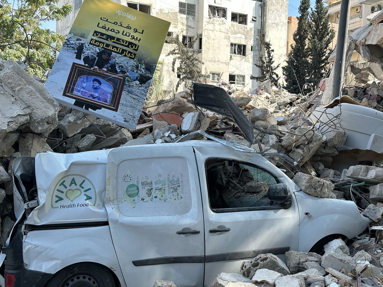 A white van was destroyed by the blast is trapped under the rubble.