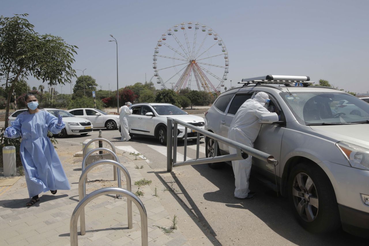 An Israeli medical worker collects COVID-19 test samples at a drive-through facility in Rishon Lezion, Israel, on June 7.