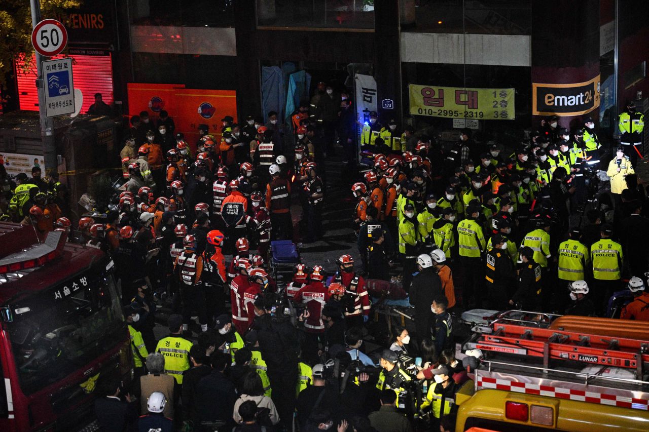 Rescue officials and police gather in the district of Itaewon in Seoul, on Sunday.
