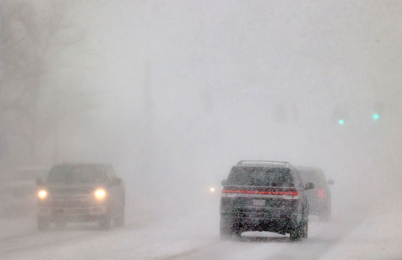 Cars drive in whiteout conditions in Orchard Park, New York, on Dec. 23.